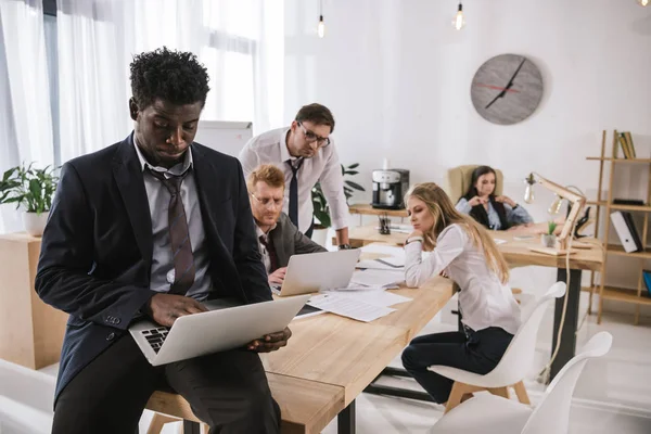 Empresarios desordenados y sobrecargados de trabajo trabajando juntos en la sala de conferencias - foto de stock