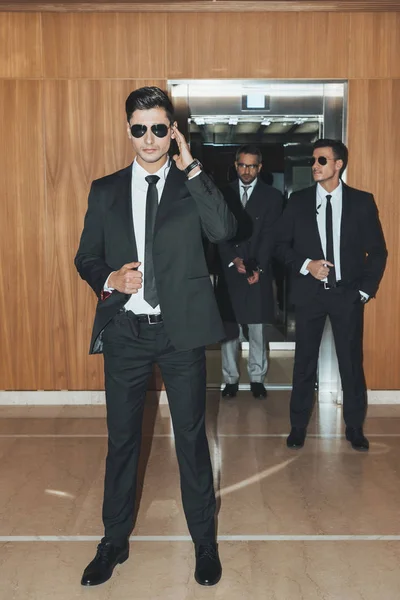 Bodyguards waiting for businessman going out from elevator — Stock Photo