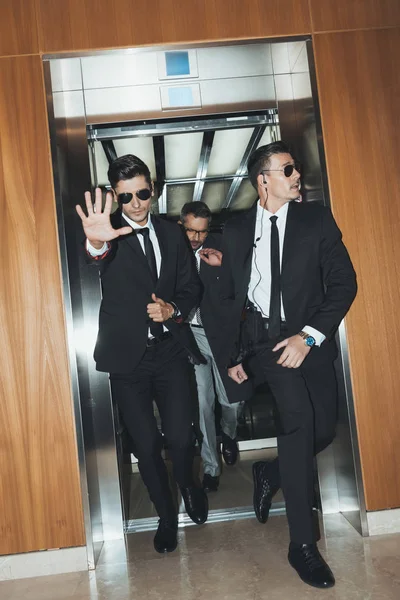 Garde du corps obstruant paparazzi lorsque la célébrité sortir de l'ascenseur — Photo de stock