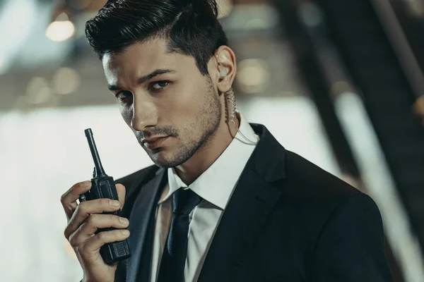 Handsome security guard with portable radio looking at camera — Stock Photo