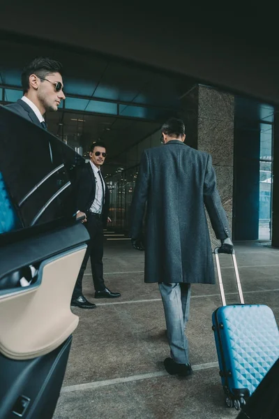 Hombre de negocios va con la bolsa de viaje azul al aeropuerto - foto de stock