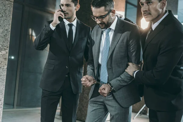 Guardias de seguridad van con el sospechoso masculino - foto de stock