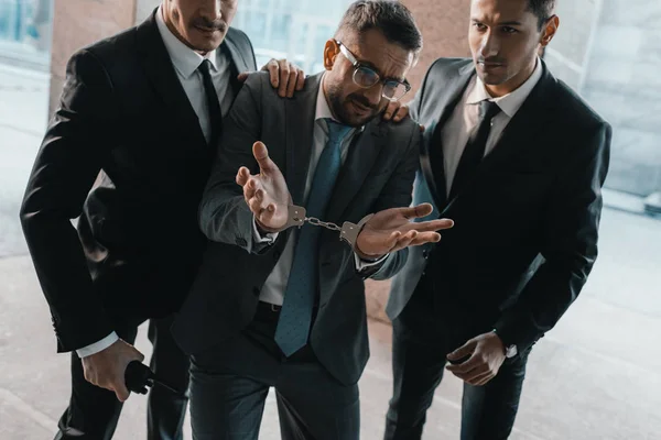 Festgenommener Täter zeigt Sicherheitsleuten achselzuckende Geste — Stockfoto