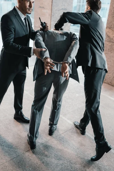 Cropped image of security guards arresting offender — Stock Photo