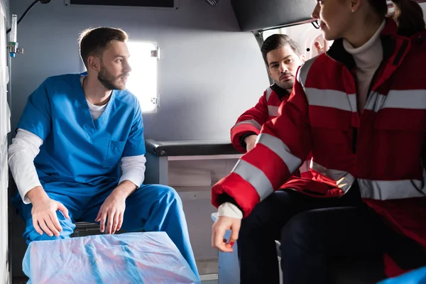 Three ambulance doctors sitting in a car — Stock Photo