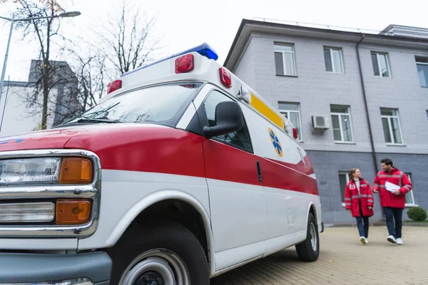 Male and female paramedics going to ambulance — Stock Photo