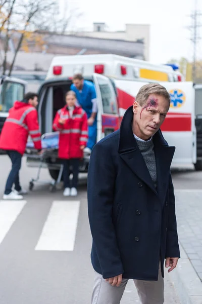 Injured man with wound on head standing and looking at camera — Stock Photo