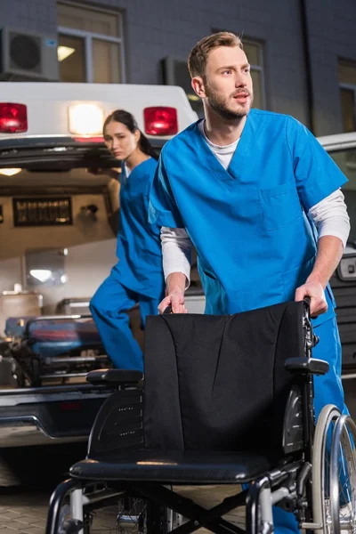 Paramédicos hombres y mujeres en el trabajo por la noche - foto de stock