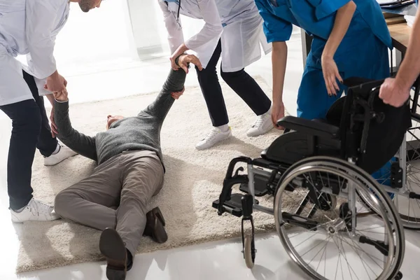 Cropped image of doctors helping unconscious man in a hospital — Stock Photo