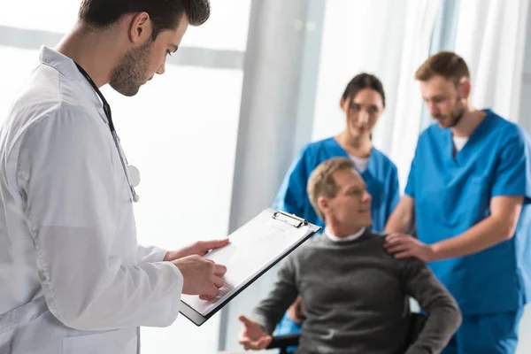 Arzt schaut im Krankenhaus in Patientenbuch — Stockfoto