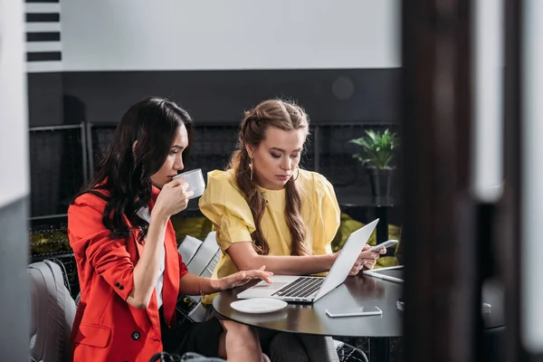Young beautiful businesswomen coworking in cafe — Stock Photo