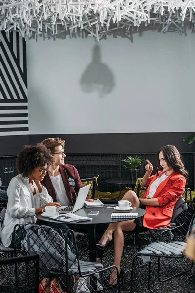 Socios comerciales multiétnicos coworking en la cafetería moderna - foto de stock