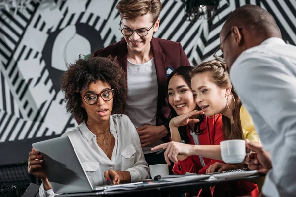 Groupe de partenaires commerciaux travaillant ensemble avec ordinateur portable au café — Photo de stock