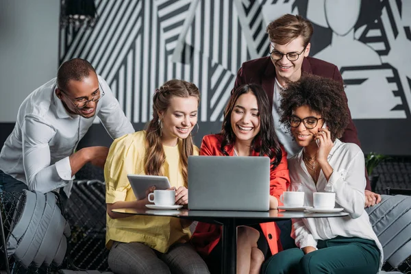 Багатоетнічна група друзів дивиться на ноутбук у кафе — Stock Photo