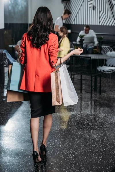 Donna con le borse della spesa andando ai suoi amici nel caffè — Foto stock