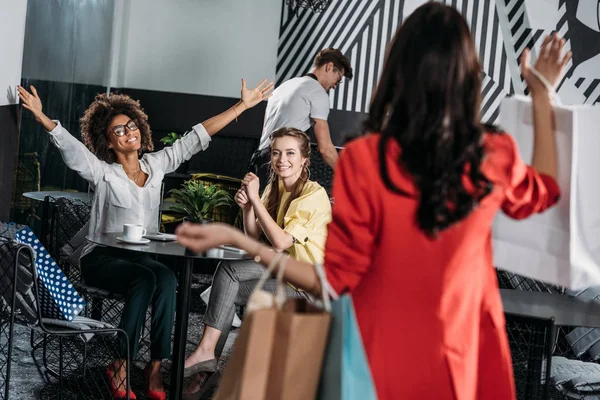 Frau mit Einkaufstüten geht zu ihren Freunden ins Café — Stockfoto