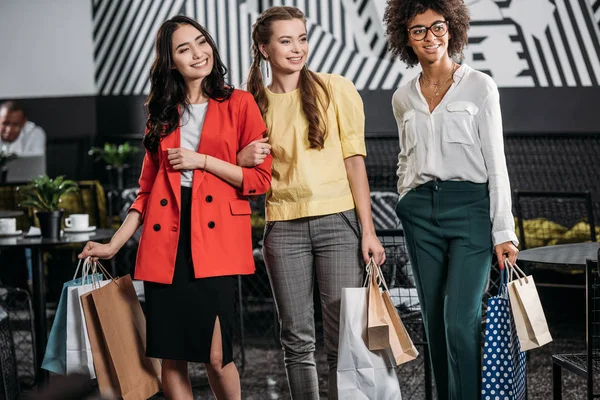 Grupo de hermosas mujeres multiétnicas con bolsas de compras - foto de stock