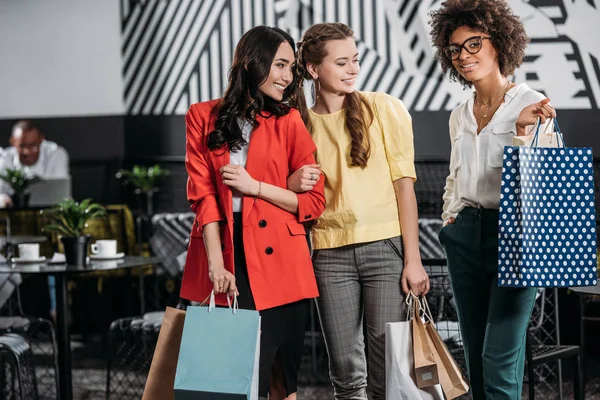 Group of young multiethnic women with shopping bags — Stock Photo
