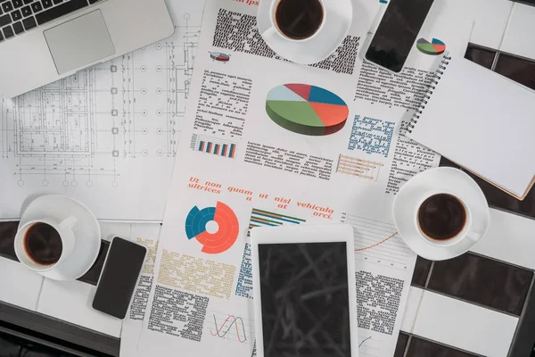 Top view of business documents on workplace with digital devices and coffee — Stock Photo