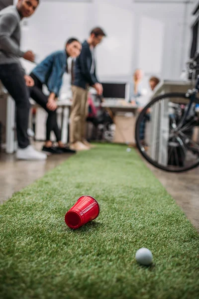 Pessoas felizes jogando em mini-golfe no escritório moderno — Fotografia de Stock