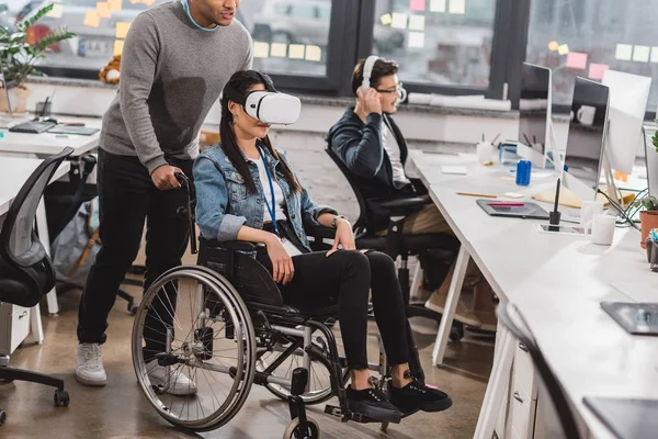 Woman in wheelchair using virtual reality glasses at modern office — Stock Photo
