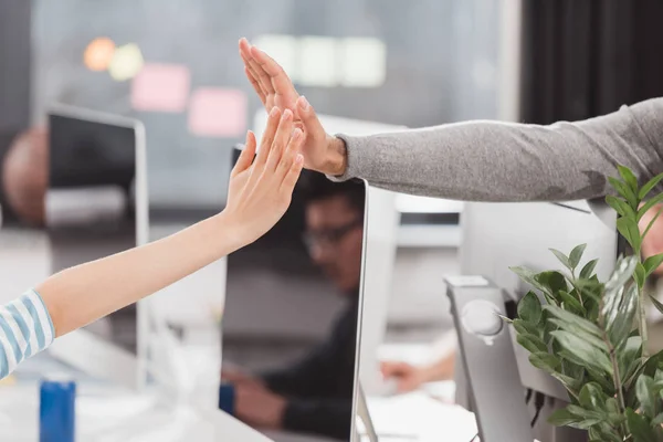 Cropped image of hands giving high five to each other at modern office — Stock Photo