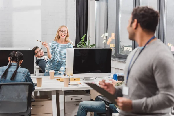 Homme avec étiquette de nom et planchette au bureau moderne — Photo de stock