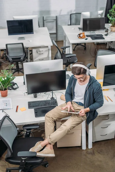 Jeune homme écoutant de la musique dans un bureau moderne vide — Photo de stock