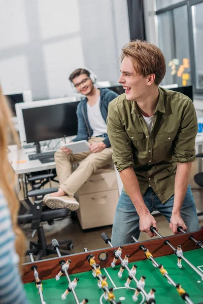 Cheerful office workers playing in table soccer at modern office — Stock Photo