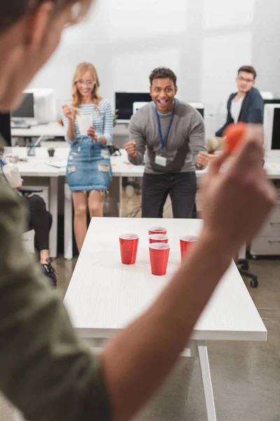 Aufgeregte Menschen spielen nach Feierabend Bier-Pong im modernen Büro — Stockfoto