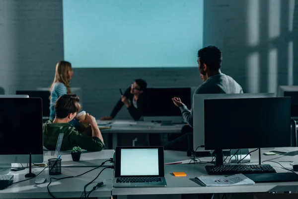 Persone che guardano la presentazione in ufficio durante la notte. schermo bianco — Foto stock