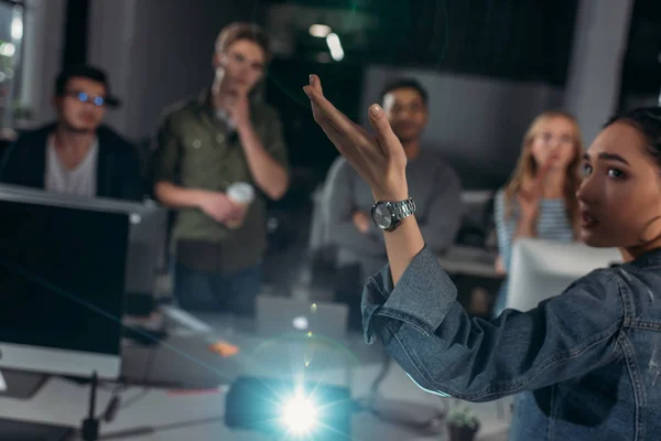 Young people watching presentation in modern office, woman pointing on screen — Stock Photo