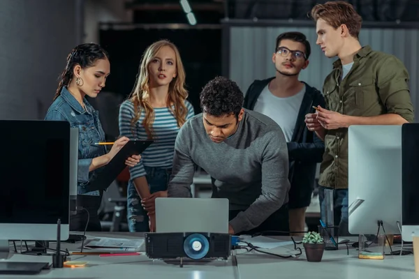 Junge Leute sehen Präsentationen im modernen Büro und schreiben etwas — Stockfoto