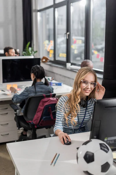 Jeune femme travaillant au bureau moderne et regardant la caméra — Photo de stock