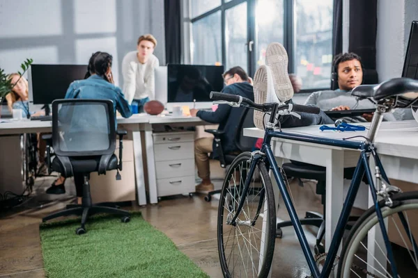 Differente people working at modern office with bicycle — Stock Photo