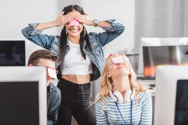Happy people with stickers on eyes in modern office — Stock Photo