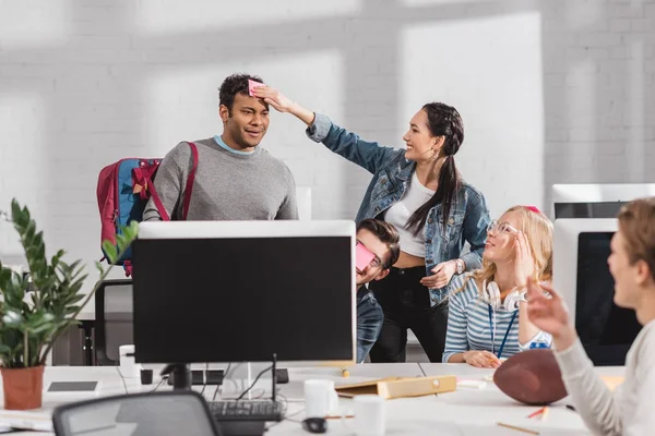 Женщина клей наклейка на голову человека в современном офисе — стоковое фото
