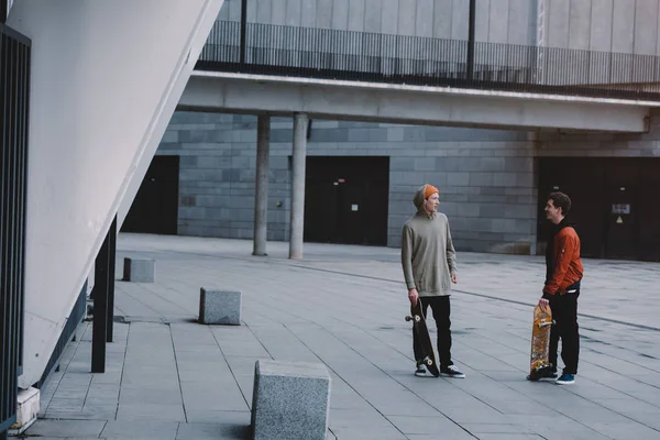 Скейтбордисты разговаривают после поездки в современном городском месте — стоковое фото