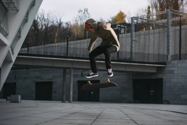 Junge Skateboarderin vollführt Sprungtrick in urbaner Lage — Stockfoto