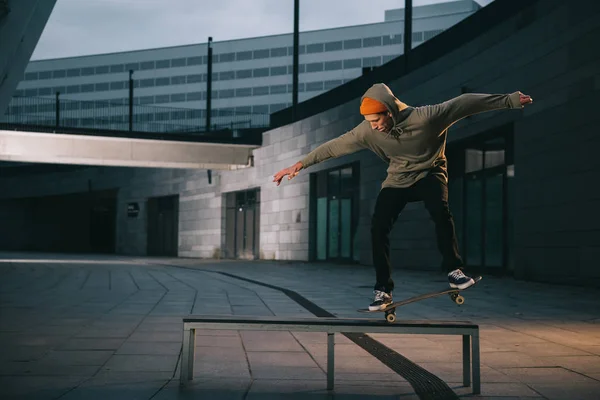 Professional skateboarder balancing with board on bench — Stock Photo