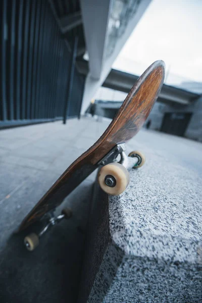 Vieille planche à roulettes penchée au coin du mur de pierre — Photo de stock