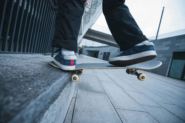 Cropped shot of skateboarder balancing on corner of stone wall — Stock Photo