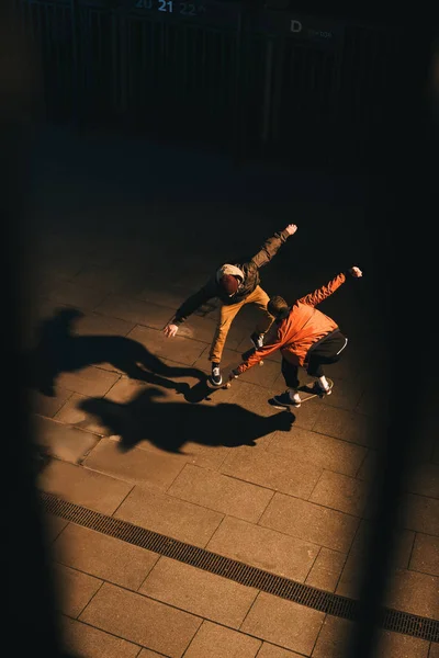 Высокий угол обзора скейтбордистов, выполняющих один трюк вместе — стоковое фото