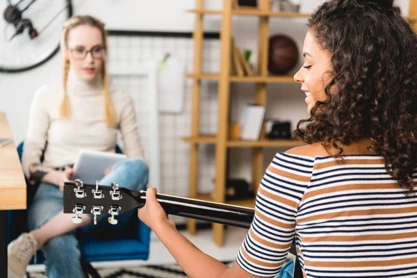 Chica afroamericana tocando la guitarra acústica para amigo — Stock Photo