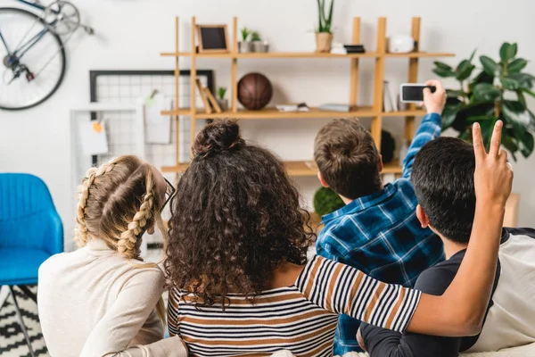 Rear view of multiethnic teenagers taking selfie with smartphone — Stock Photo
