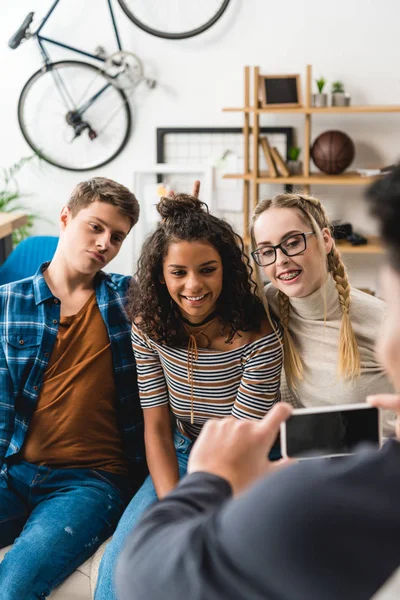 Cropped image of boy taking photo of multicultural friends — Stock Photo