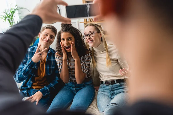 Cropped image of boy taking photo of multiethnic friends — Stock Photo