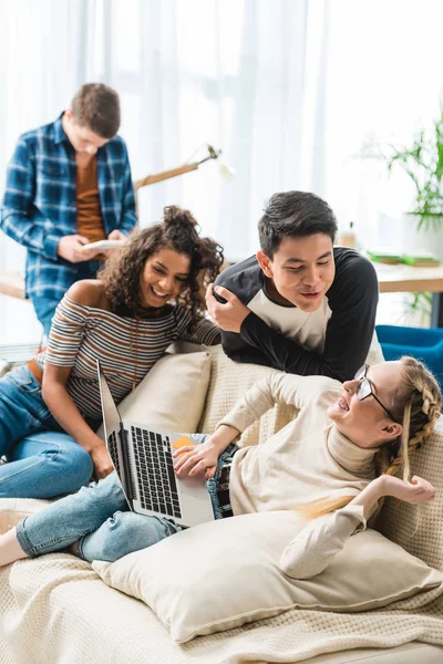 Heureux multiculturels adolescents parler et utiliser un ordinateur portable — Photo de stock