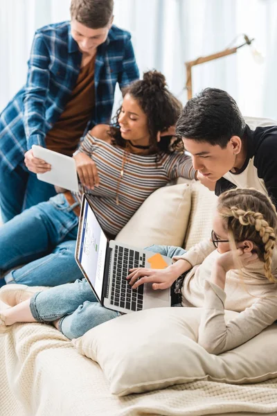 Sorridenti adolescenti multiculturali che guardano laptop con pagina facebook caricata — Foto stock