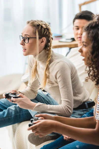 Chicas multiétnicas jugando videojuegos en casa - foto de stock